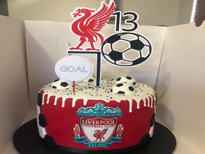 Liverpool cake. Gluten free and Dairy free chocolate mud cake, decorated with edible images, edible chocolate soccer balls and drip. Topper by Chocca Mummas<br>Posted: April 22nd, 2022.