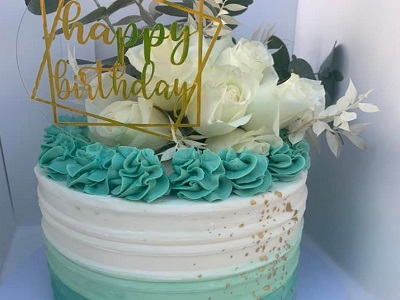 White chocolate mudcake, layered with white chocolate buttercream, finished in green ombre buttercream and gold specks<br>Posted: May 24th, 2022.